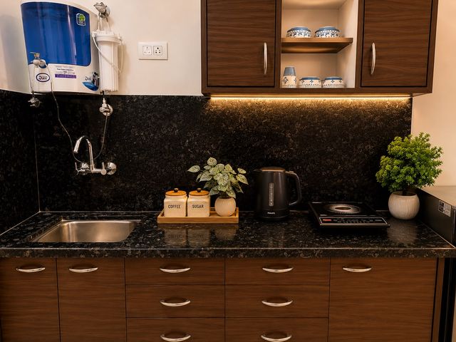 Kitchenette counter with electric kettle, induction cooktop, RO water purifier and coffee and sugar jars
